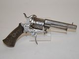 a silver revolver with a wooden handle on a white surface