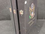 two books are sitting on a gray surface with a black background