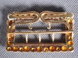 an image of a close up of a brooch with beads on it