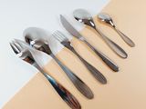 five forks and spoons on a table with a white background