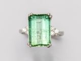 un gros plan d'une bague en tourmaline verte et diamants