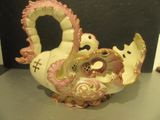 a white and pink swan shaped vase on a table