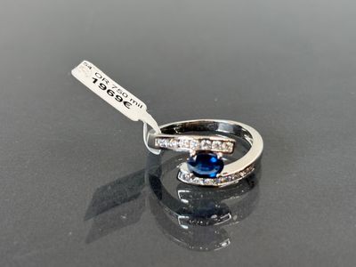 une bague avec une pierre bleue sur un fond noir
