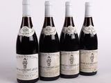 four bottles of wine are lined up in a row on a table