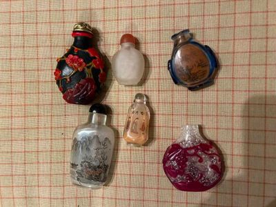 cinq petites bouteilles en verre posées sur une nappe à carreaux