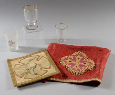 un tissu rouge orné d'un motif, à côté d'un verre