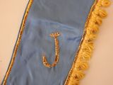 a blue and gold scarf with a gold letter j on it