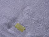 a close up of a piece of fabric with a piece of yellow tape sticking out of it