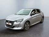 La voiture argentée est garée dans une pièce blanche au sol noir.