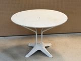 une table blanche avec un plateau blanc posée sur un sol en ciment