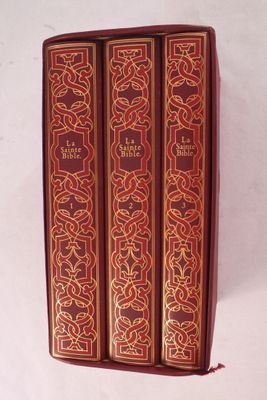 trois livres rouges superposés sur une surface blanche