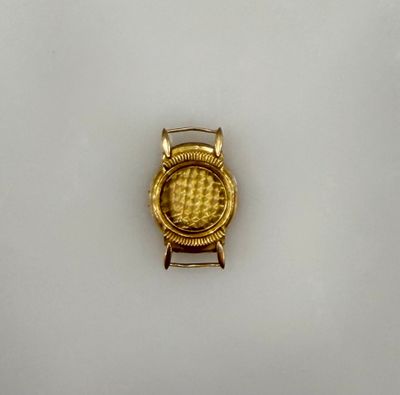 une montre dorée posée sur une surface blanche
