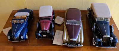 Plusieurs petites voitures sont alignées en rang sur une table en bois