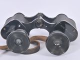 an old pair of binoculars sitting on top of a white surface