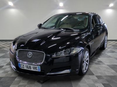 La Jaguar noire est garée dans une grande pièce au sol carrelé en damier.