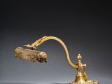 a gold plated desk lamp with a brass shade and a brass handle