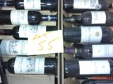 plusieurs bouteilles de vin dans un carton sur lequel est apposée une étiquette de prix