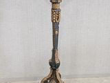 an image of a tall candle stand with a candle on top of it