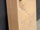 a cardboard box sitting on the ground next to a wall