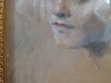 a painting of a woman ' s face is shown in a gold frame
