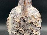 a small vase with a bird on it on a table