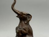 statue représentant un éléphant tenant un éléphanteau dans sa trompe
