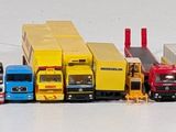 a lot of toy cars that are lined up on the table