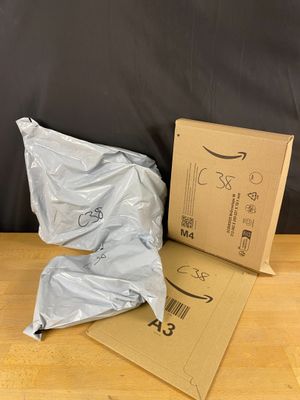 two bags of food sitting on the floor next to a cardboard box