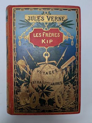 un vieux livre rouge et bleu dont la couverture est bordée d'or