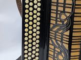 an old black accordion sitting on top of a white table