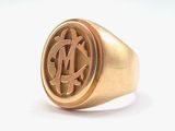 a close up of a gold signet ring with a man ' s initials on it