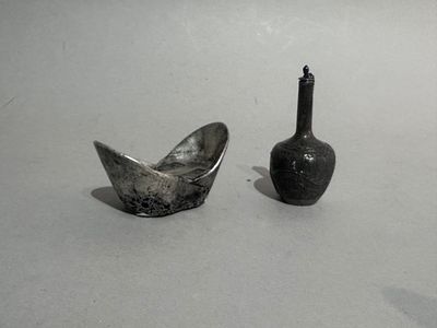two small vases sitting next to each other on a table