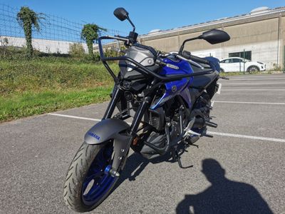 a blue motorcycle parked in a parking lot next to a building
