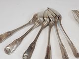 a lot of silver spoons and forks laid out on a table