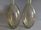 two glass vases sitting next to each other on a table