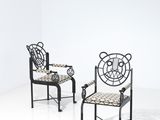 pair of wrought iron chairs in the shape of spider webs
