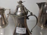 three silver vases sitting on a table with labels on them