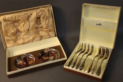 two sets of silverware in a box on a table