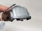 a person holding a silver toy car in their hand