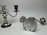 two silver candlesticks on a table with a white background