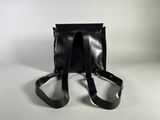 a black leather bag with two straps on a white background