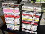 books stacked on a table in front of a window in a room