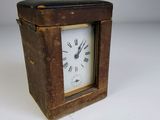 a small wooden clock with roman numerals on the face