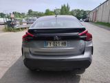 the rear end of a silver car parked on the side of a road