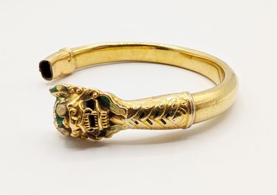 a close up of a gold ring with a green stone in the middle