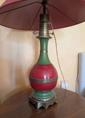 une lampe rouge et verte posée sur une table, avec un parapluie rose