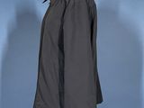 a black jacket on a mannequin stand against a blue background