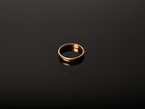 a gold ring sitting on top of a black surface