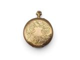 an antique gold pocket watch on a white surface with a white background