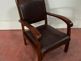 un fauteuil en cuir marron posé sur un sol rouge